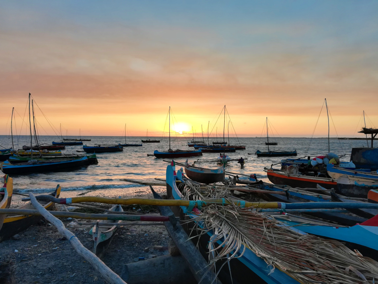 Fishing boats on a beach at sunset